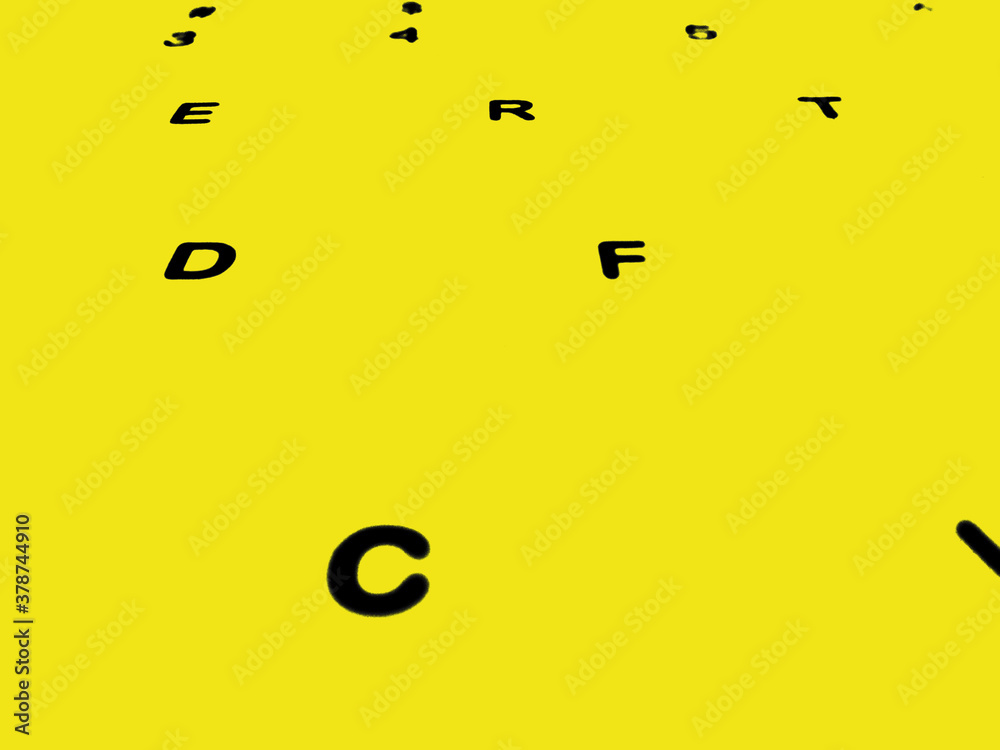 Fototapeta premium Creative Fine Art Image Illustration of Dark Black English Alphabet Letters On Yellow Glowing Background Copy Space For Text. Modern abstract front style in computer keyboard typewriter sequence order