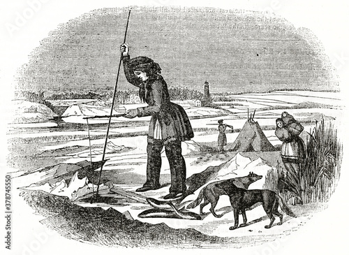 Chippewa native american people ice fishing hole on winter landscape. Ancient engraving style art by unidentified author, The Penny Magazine, London 1837