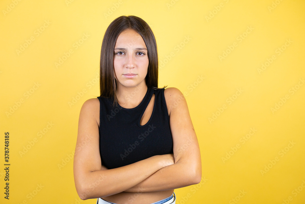 Beautiful young girl kid over isolated yellow background thinking looking tired and bored with crossed arms Beautiful young girl kid over isolated yellow background thinking looking tired and bored with crossed arms