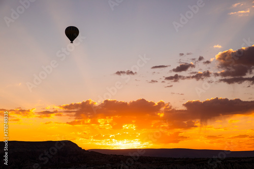 Hot air balloons flying over a volcanic landscape at Cappadocia, Turkey.