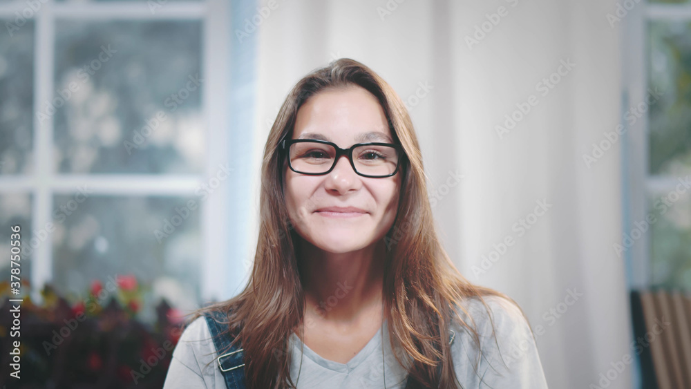 Happy smiling woman in glasses looking at camera standing at home Happy smiling woman in glasses looking at camera standing at home