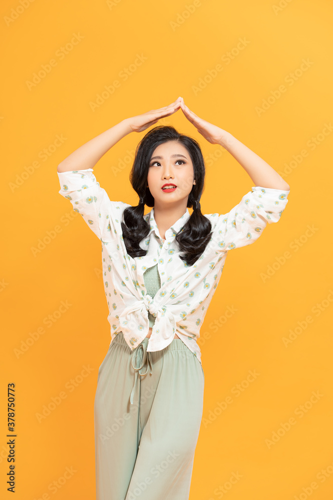 Photo of nice pleased woman in raincoat making roof gesture and smiling isolated over white background Photo of nice pleased woman in raincoat making roof gesture and smiling isolated over white background