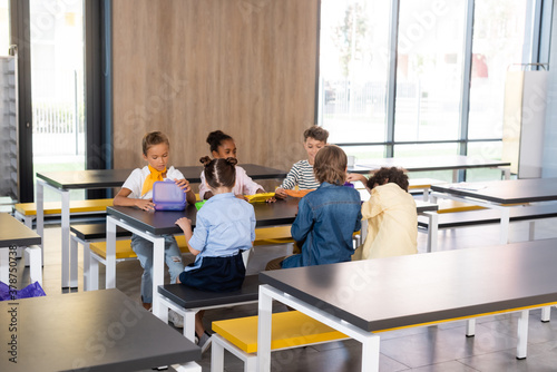 фотографія multicultural pupils sitting in school canteen during dinner brake