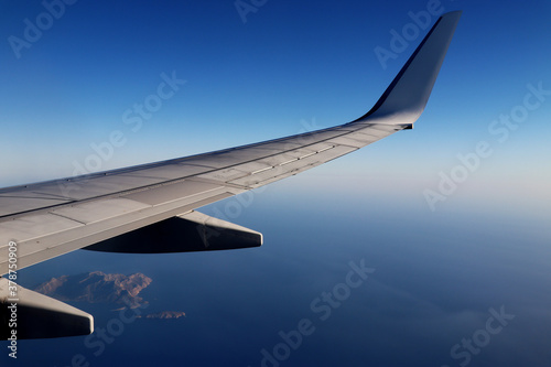 Plane wing over the ocean with islands