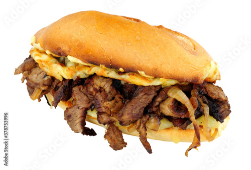 Steak and cheese sandwich with fried onions in a crusty bread roll isolated on a white background