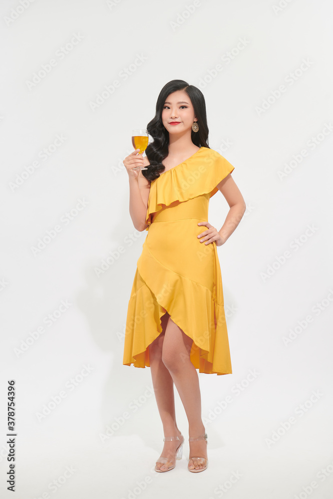 Charming beautiful woman with yellow luxury dress cheerful hand hold yellow wine glass drink in new year party festival concept Charming beautiful woman with yellow luxury dress cheerful hand hold yellow wine glass drink in new year party festival concept