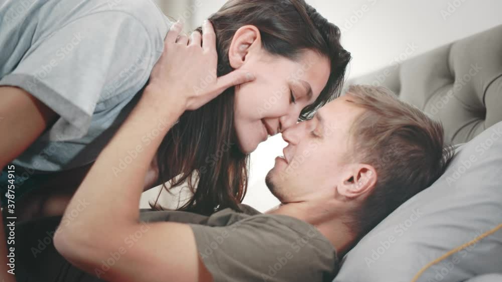 Close up side view of sexy young couple kissing in bed Close up side view of sexy young couple kissing in bed