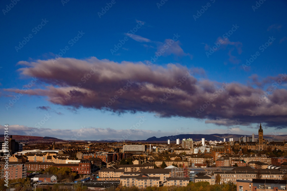 Glasgow / Scotland - Nov 13, 2013: Fall in the city. Sunset panorama view.  University of Glasgow and mountains. Blue sky with clouds.