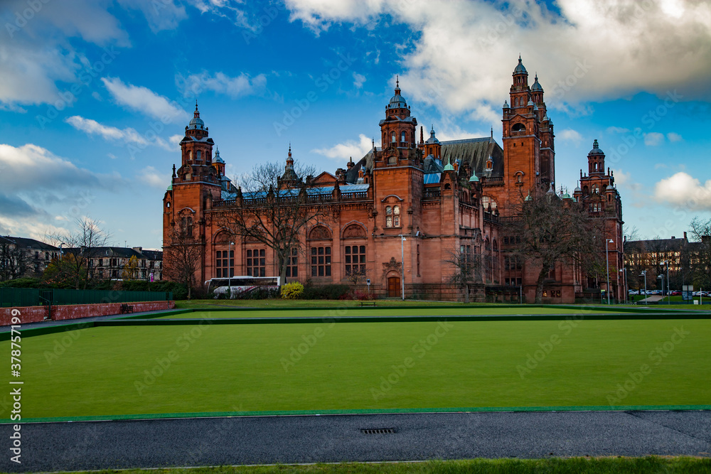 Glasgow / Scotland - Nov 13, 2013: View on Kelvingrove Art Gallery and Museum at evening an sunset. Green grass in front.