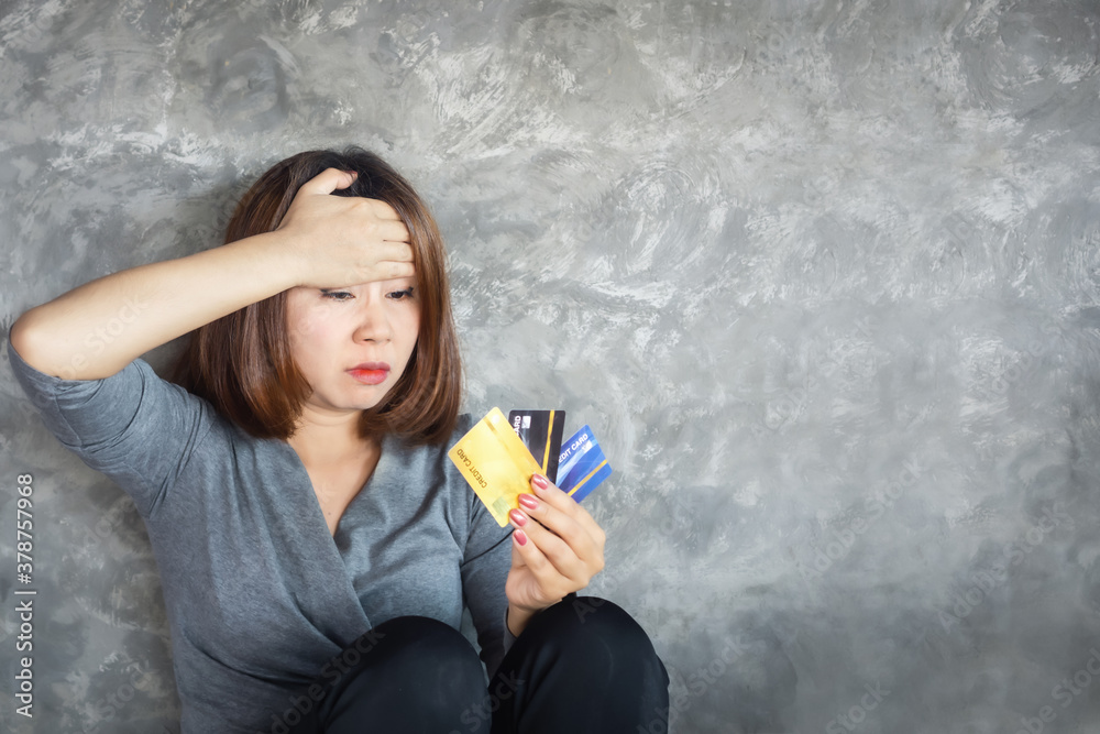 stressed Asian woman hand holding credit cards having problem with overspending and debt 