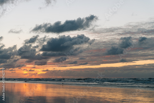  Sea landscape  Seascape  sunset  beautiful orange cloud sky  Reflections in the wet sand and waves washing up  Ameland  Wadden Island  nature conservation area  Friesland  The Netherlands