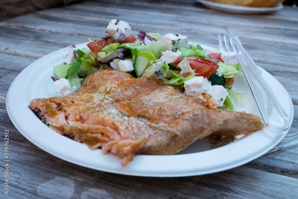 Delicious hungarian street food - smoked salmon fillets with greek salad