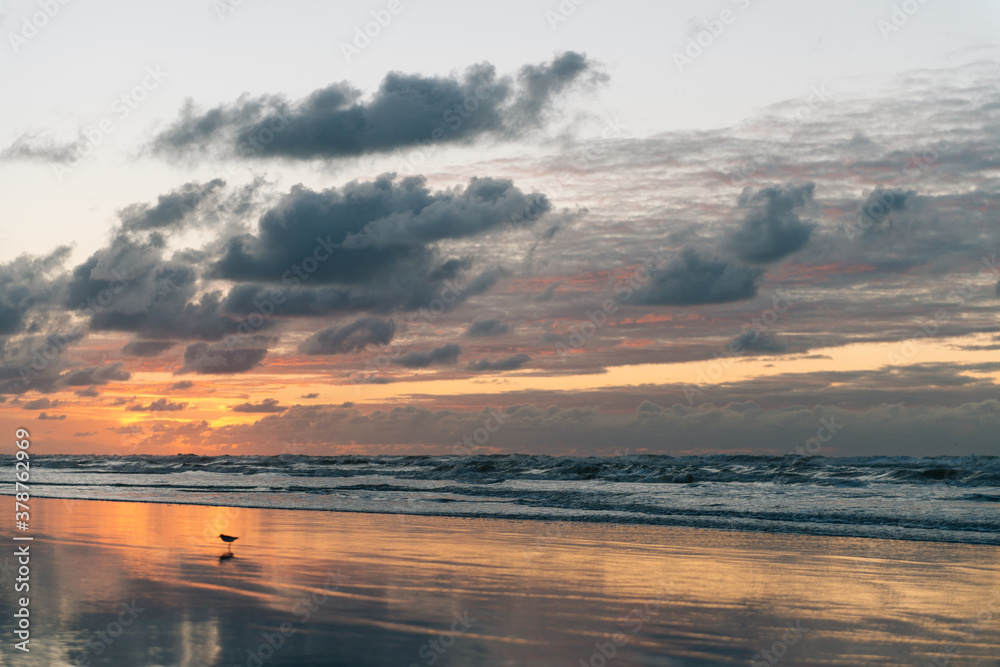 Obraz premium Sea landscape, Seascape, sunset, beautiful orange cloud sky, Reflections in the wet sand and waves washing up, Ameland, Wadden Island, nature conservation area, Friesland, The Netherlands