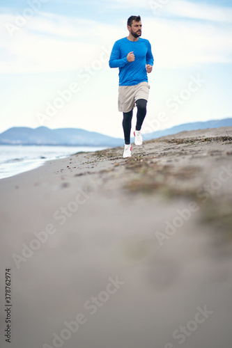 Young man jogging on the beach
