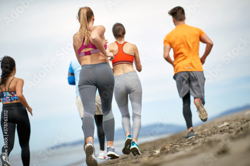 Group of young people jogging on the beach
