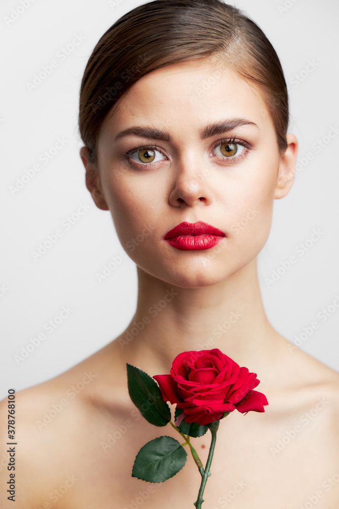Girl with bare shoulders model holding a rose bright makeup 