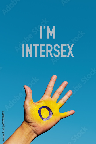 text I am intersex and intersex flag in the hand photo