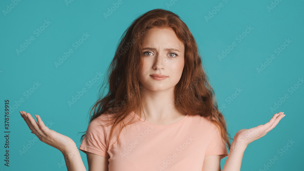 Attractive confused woman shrugging up and showing what gesture on camera isolated Attractive confused woman shrugging up and showing what gesture on camera isolated