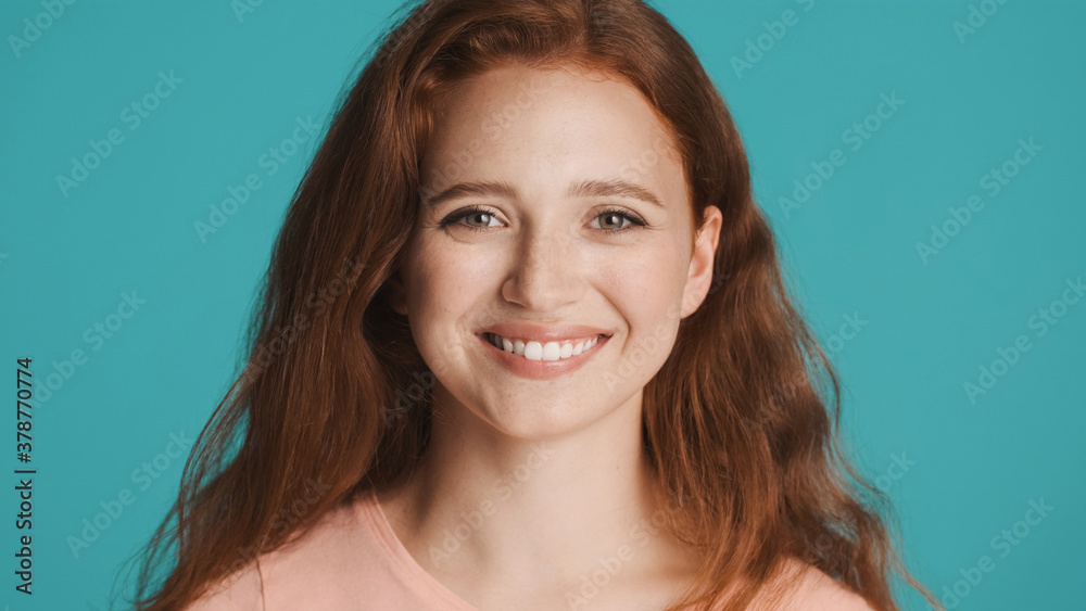 Pretty cheerful girl happily looking in camera and smiling over colorful background Pretty cheerful girl happily looking in camera and smiling over colorful background