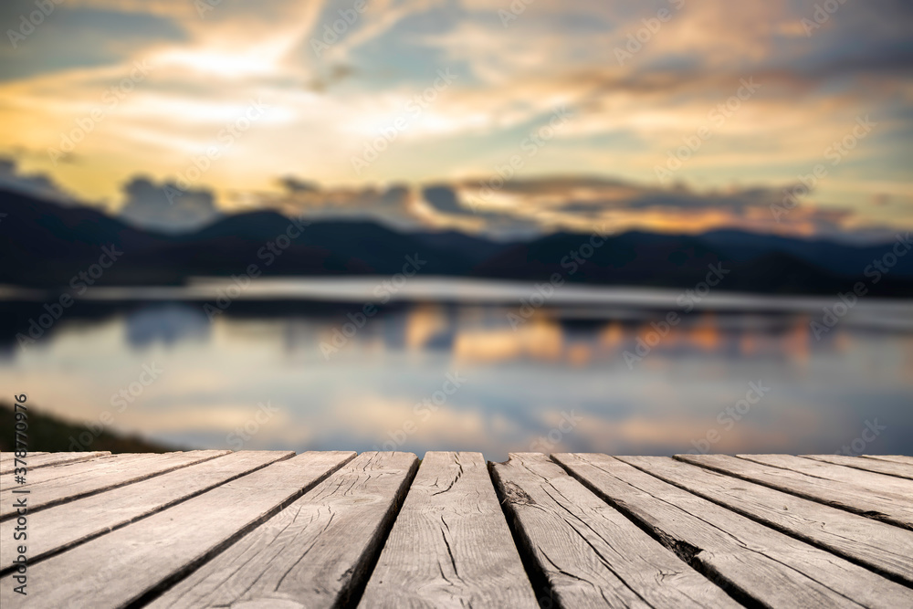 Showcase an old wooden table shelf on a beautiful sunset and blurred nature background.	