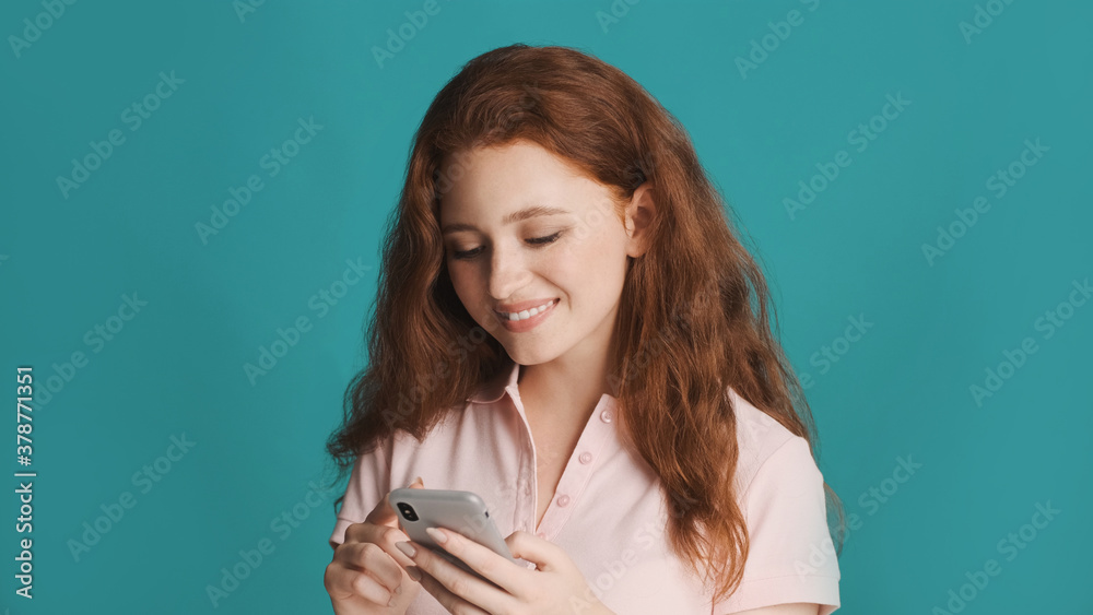 Pretty smiling girl happily using smartphone over colorful background Pretty smiling girl happily using smartphone over colorful background