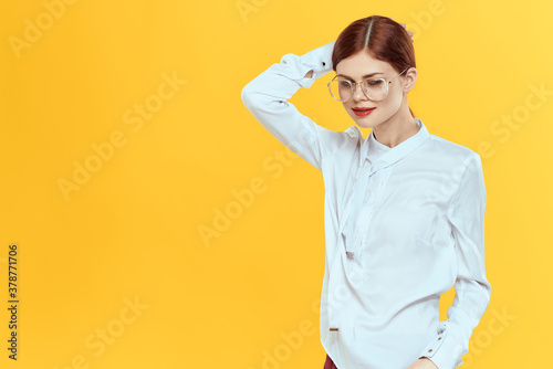 woman in white shirt wearing glasses red lips elegant style yellow isolated background © SHOTPRIME STUDIO