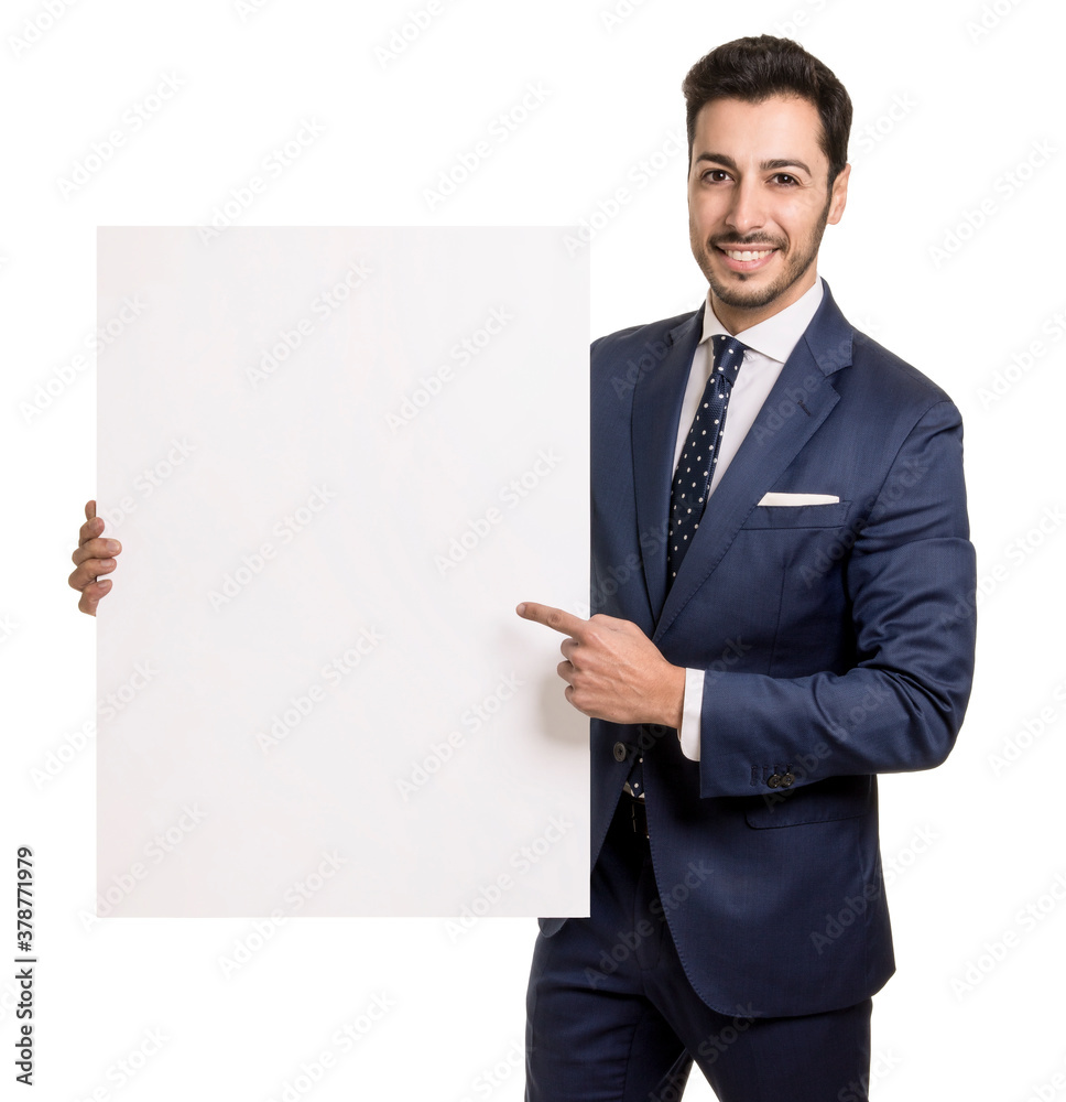 Portrait of happy smiling young businessman holding and pointing to blank board in blue suit looking straight 