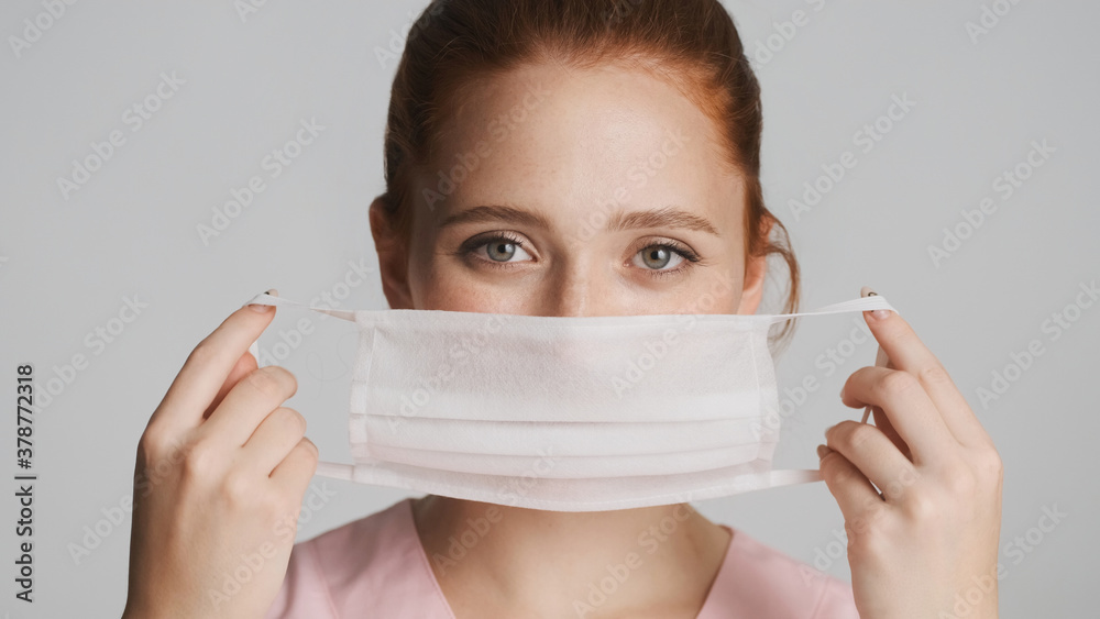 Portrait of nurse wearing medical mask over white background. Safety first concept