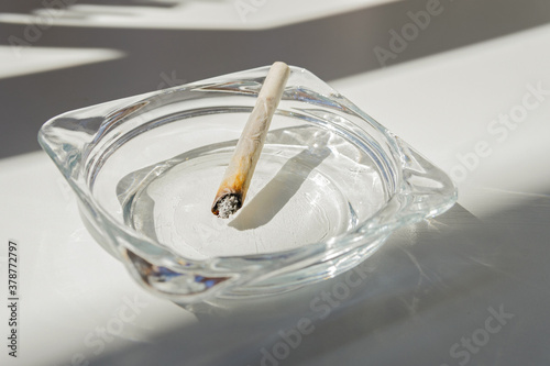 Rolling cigarette turned off in an ashtray. Smoking concept. Marijuana joint.