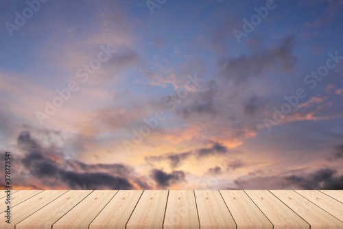 Empty wood plank table top with sunset blur background. wooden table with blurred sunset with clouds on background - For product display.