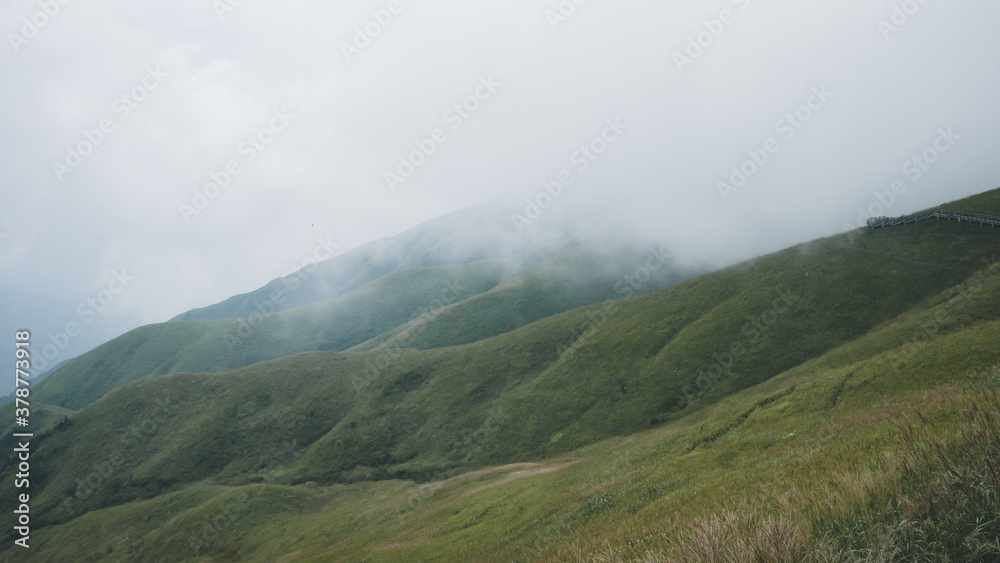 Meadow landscape with mountains covered by clouds on Wugong Mountain in Jiangxi, China