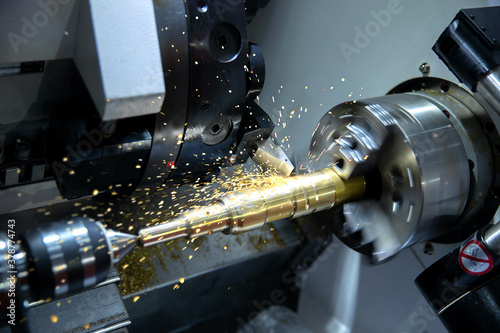 Metal machine tools industry. CNC turning machine high-speed cutting is operation.flying sparks of metalworking photo