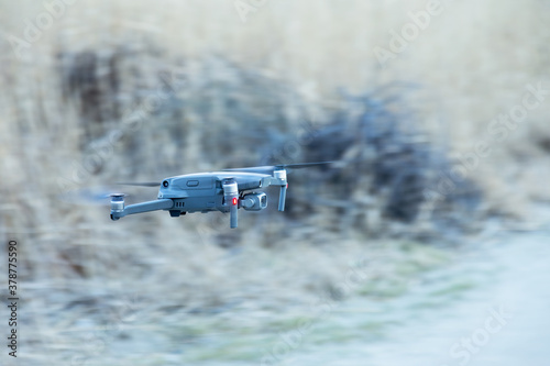 Fototapeta Naklejka Na Ścianę i Meble -  Flying drone on blurred background of faded grass