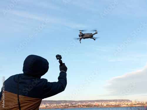 Man shoots a drone flying in the sky on a video camet. photo