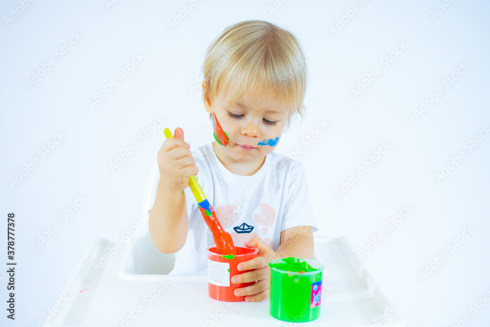 Amazed toddler boy with colorful paints on face isolated on white background Amazed toddler boy with colorful paints on face isolated on white background