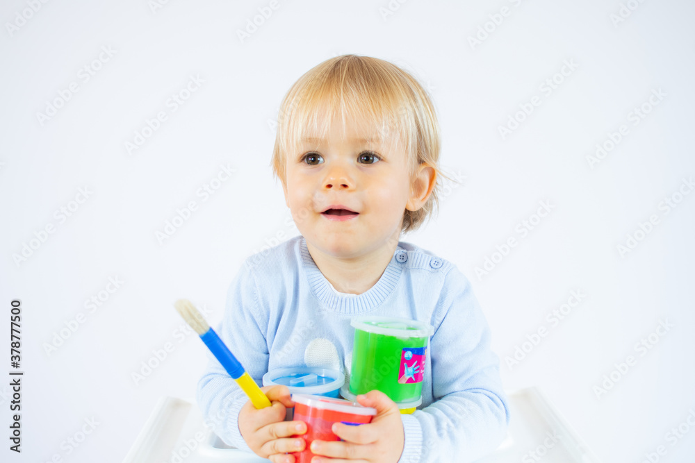 Amazed toddler boy with colorful paints on face isolated on white background Amazed toddler boy with colorful paints on face isolated on white background