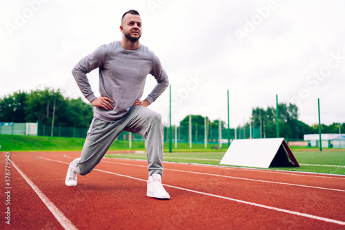 Confident sportsman stretching on track © BullRun