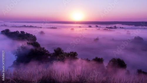 Timelapse of pink sunrise on misty valley of Siverskiy Donets river near Zmiiv city, Ukraine photo