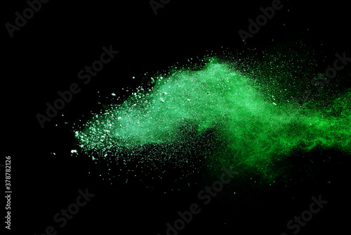 Green powder explosion on black background. Colored cloud. Colorful dust explode. Paint Holi.
