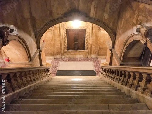 Impressive marble staircase or stairwell in historic public building with railing, steps, archs and archways and columns and ornaments photo