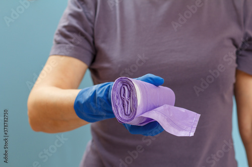 Woman holding garbage bags on a blue background.