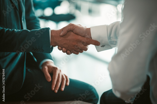 Employees shake hands at a business meeting. Making a deal between partners. Two men in suits. High quality photo.