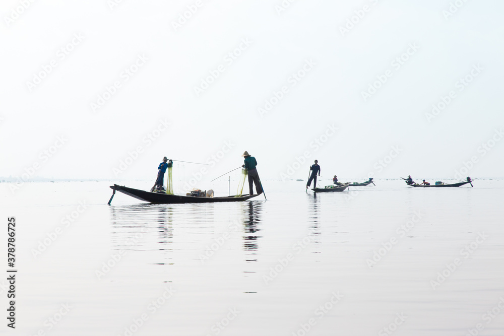 Naklejka premium Inle Lake, Myanmar 12/16/2015 traditional Intha fisherman rowing with one leg