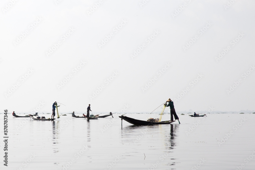 Naklejka premium Inle Lake, Myanmar 12/16/2015 traditional Intha fisherman rowing with one leg