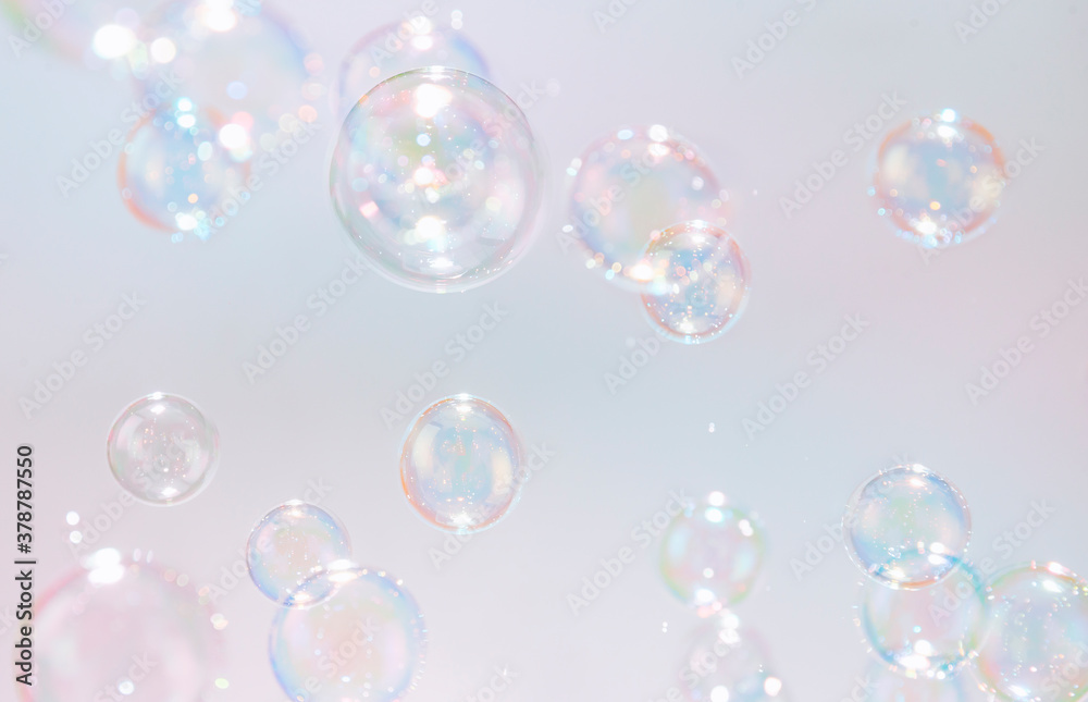 Colorful rainbow soap bubbles float in the air.