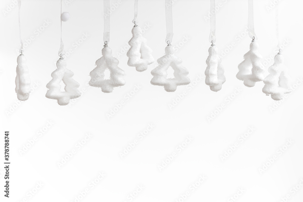white toy Christmas trees hang from above, New Year's white decor. white toy Christmas trees hang from above, New Year's white decor.