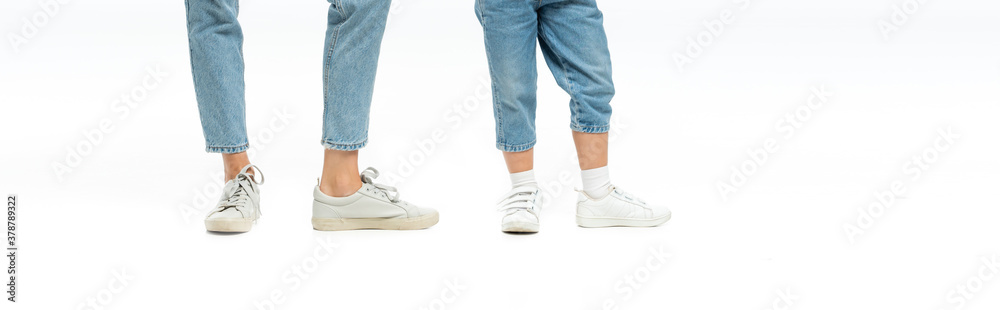 cropped view of mother and daughter in jeans and sneakers isolated on white, panoramic shot