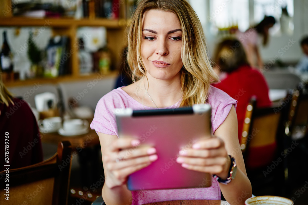 Thoughtful woman using tablet in cafe Thoughtful woman using tablet in cafe