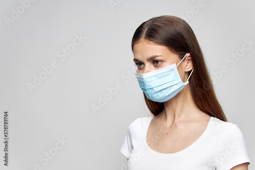 girl with a medical mask on her face looks towards Copy Space