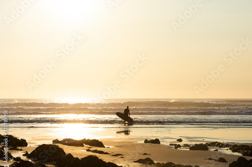 Schilderij op canvas Surfer Emerges from the Ocean - Bude, Cornwall, England